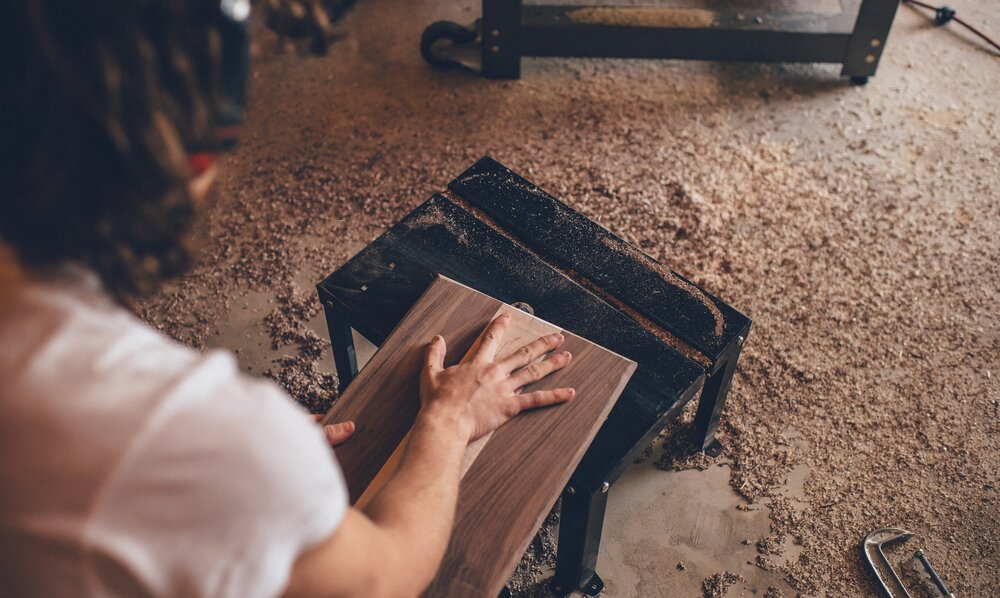 Person arbeitet mit Holz in einer Werkstatt. | © unsplash
